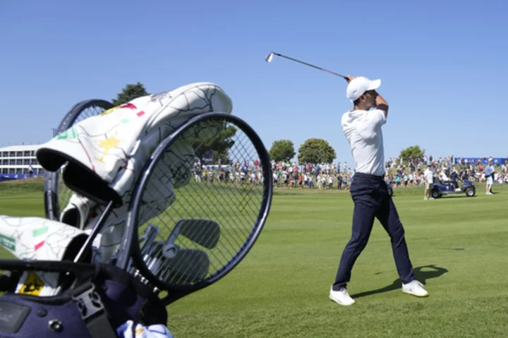 Novak Djokovic takes his tennis racket onto the 1st tee of golf's Ryder Cup All-Star match