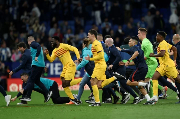 Triumphant Barca players chased from pitch by angry Espanyol fans